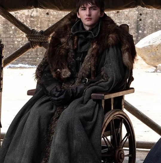 Un jeune homme dans un fauteuil roulant en bois.