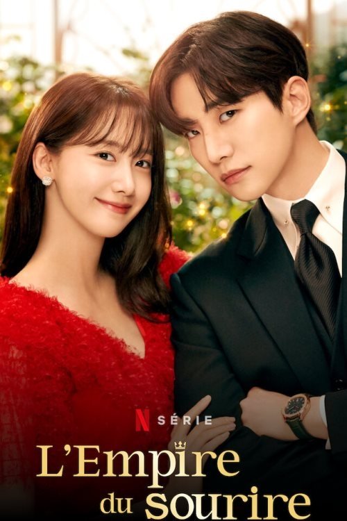 Un homme en costume à côté d'une femme souriante en robe rouge.